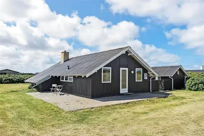 a small black house on a grass field at 958-Thisted-Kobbelsti-22 in Torsted