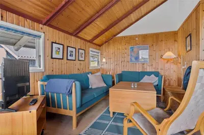 a living room with a blue couch and a tv at 958-Thisted-Kobbelsti-22 in Torsted
