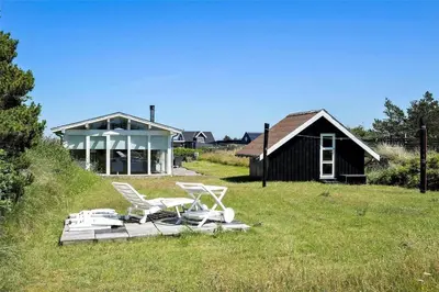 a couple of chairs and a house in a field at 1003-Thisted-Ajs-Molls-Vej-2 in Torsted