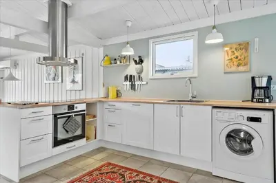 a kitchen with white cabinets and a washer and dryer at 1003-Thisted-Ajs-Molls-Vej-2 in Torsted