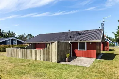 a red house with a wooden fence in front of it at 715-Thisted-Tunvej-22 in Thisted