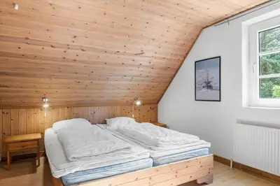 a bed in a room with a wooden ceiling at 100-Thisted-Kapelvej-1 in Thisted