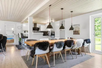 a kitchen and dining room with a wooden table and chairs at 100-Thisted-Kapelvej-1 in Thisted