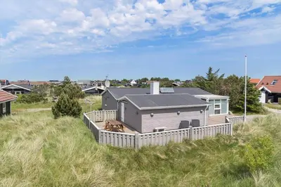 a house with a fence in the middle of a field at 514-Thisted-Fiskervej-53 in Thisted