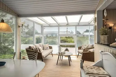 a living room with a conservatory with a table and chairs at 514-Thisted-Fiskervej-53 in Thisted