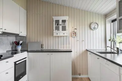 a kitchen with white cabinets and a clock on the wall at 514-Thisted-Fiskervej-53 in Thisted