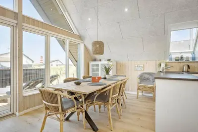 a dining room with a table and some windows at 842-Thisted-Orredvej-40 in Thisted