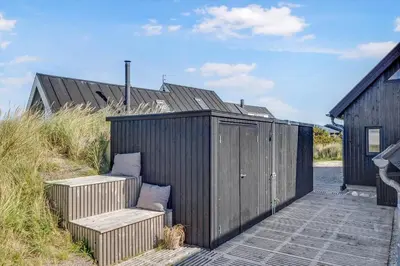 a wooden deck with two chairs and a building at 842-Thisted-Orredvej-40 in Thisted