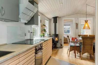 a kitchen with a stove top oven next to a table at 589-Thisted-Klitrosevej-3 in Thisted