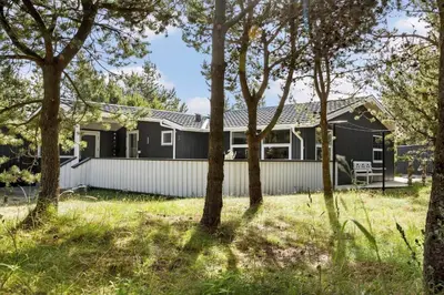 a black house with trees in the foreground at 589-Thisted-Klitrosevej-3 in Thisted