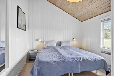 a bedroom with a bed with a blue comforter at 571-Thisted-Tunvej-21 in Thisted