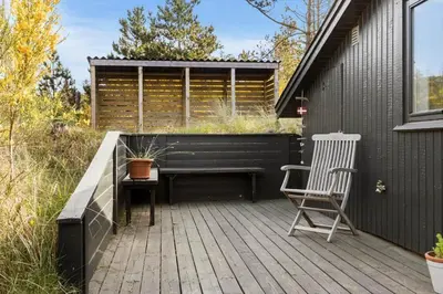 a wooden deck with a bench and a chair on it at 788-Thisted-Blamunkevej-46 in Thisted