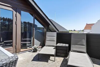 two chairs sitting on a patio with windows at 896-Thisted-Fiskervej-81 in Thisted