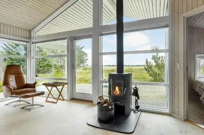 a living room with a fireplace and a chair at 248-Thisted-Molgaardsvej-28 in Thisted
