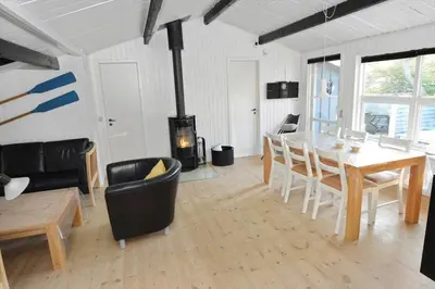 a living room with a dining table and a fireplace at 1321-Thisted-Blamunkevej-58 in Thisted