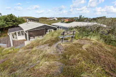 a bench sitting on top of a hill with a house at 996-Thisted-Bavnbak-25 in Torsted