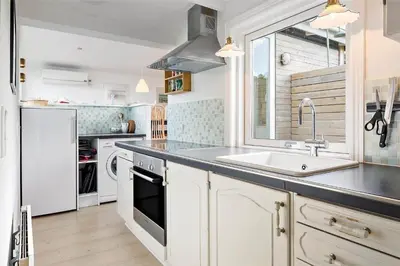 a kitchen with white cabinets and a sink and a window at 996-Thisted-Bavnbak-25 in Torsted