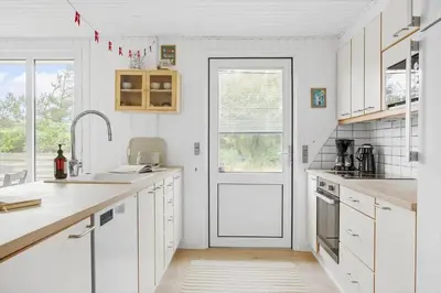 a kitchen with white cabinets and a white door at 269-Vestervig-Blishonevej-19 in Vestervig