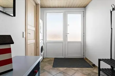 a laundry room with a door and a washing machine at 497-Thisted-Nordsovej-26 in Thisted