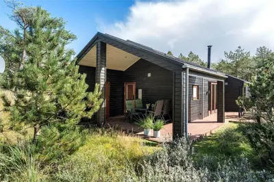 a small black house with a wooden deck at 748-Thisted-Blamunkevej-65 in Thisted