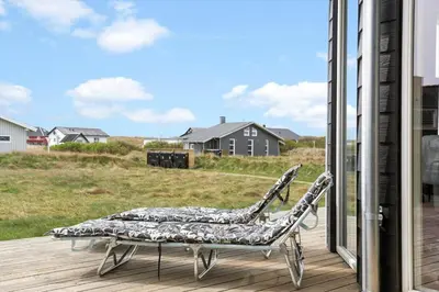 a chair sitting on a deck next to a window at 262-Vestervig-Magevej-15 in Vestervig