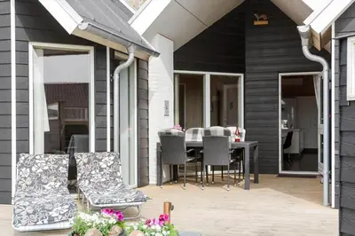 a patio with a table and chairs on a house at 262-Vestervig-Magevej-15 in Vestervig