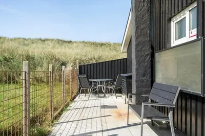 a patio with chairs and a table and a fence at 306-Vestervig-Klitvej-6 in Vestervig
