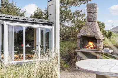 a stone fireplace next to a patio with a table at 806-Thisted-Nordsovej-39 in Thisted
