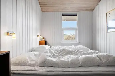 a bedroom with a large white bed with a window at 941-Thisted-Klitstien-37 in Torsted