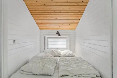 a bed in a white room with a wooden ceiling at 851-Thisted-Blabaervej-1 in Thisted