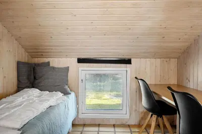 a bedroom with a bed and a window and two chairs at 1312-Thisted-Kristinesvej-38 in Thisted