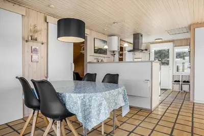 a kitchen with a table and black chairs in a room at 1312-Thisted-Kristinesvej-38 in Thisted