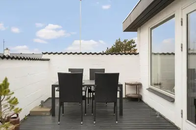 a patio with a table and chairs on a deck at 426-Thisted-Havbovej-26 in Thisted