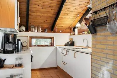 a kitchen with white cabinets and a brick wall at 510-Thisted-Egebaksandevej-10 in Thisted