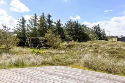 a wooden boardwalk in a field with a play structure at 658-Thisted-Laksevej-8 in Thisted
