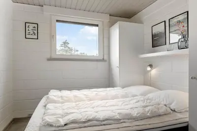 a large white bed in a room with a window at 994-Thisted-Gravsesvej-20 in Torsted