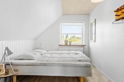 a white bedroom with a bed and a window at 600-Vestervig-Krik-Strandvej-100 in Vestervig