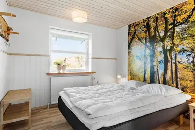 a bedroom with a large bed with a painting on the wall at 600-Vestervig-Krik-Strandvej-100 in Vestervig