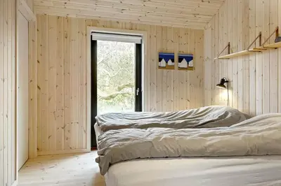 two beds in a room with wooden walls at 113-Thisted-Muslingevej-13-D in Thisted