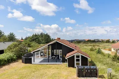 a black house with a red roof on a field at 546-Thisted-Kuttervej-16 in Thisted