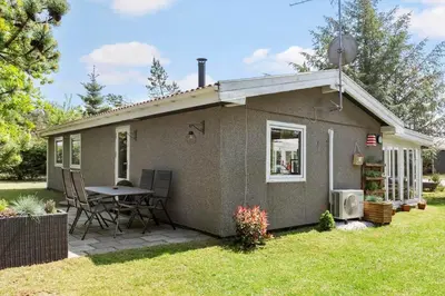 a small house with a table and chairs in the yard at 317-Thisted-Molgaardsvej-65 in Thisted