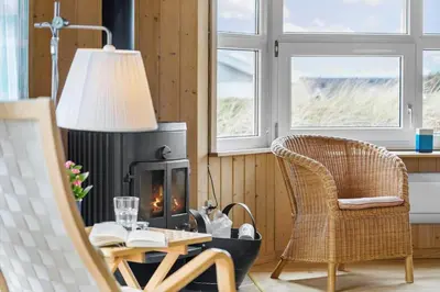 a living room with a fireplace and a table and chairs at 947-Thisted-Niels-Vognmands-Vej-20 in Torsted