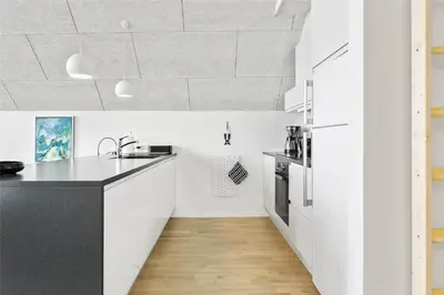 a kitchen with white cabinets and a black counter top at 793-Thisted-Havstokken-24-1 in Thisted