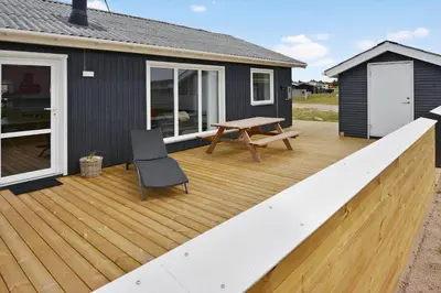a wooden deck with a bench and a table at 867-Thisted-Nordsovej-66 in Thisted