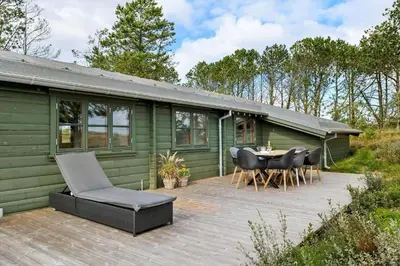 a green cabin with a table and chairs on a deck at 1307-Bedsted-Thy-Nordre-Redningsvej-4 in Bedsted Thy