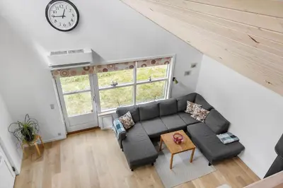 a living room with a couch and a clock on the wall at 669-Thisted-Kristinesvej-68 in Thisted