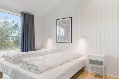 a white bedroom with a large bed and a window at 1056-Thisted-Johns-Vej-16 in Torsted