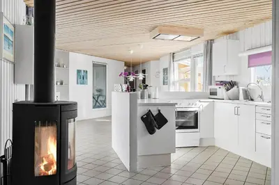 a kitchen with a fireplace in the middle of a room at 1039-Thisted-Niels-Vognmands-Vej-19 in Torsted