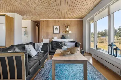 a living room with a black leather couch and a table at 234-Thisted-Kuttervej-9 in Thisted