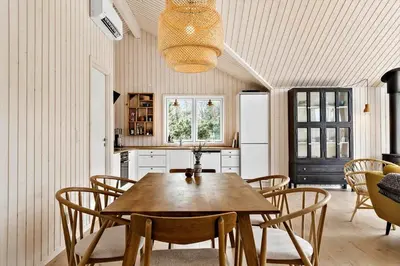 a dining room with a wooden table and chairs at 192-Snedsted-Sarasvej-12 in Snedsted